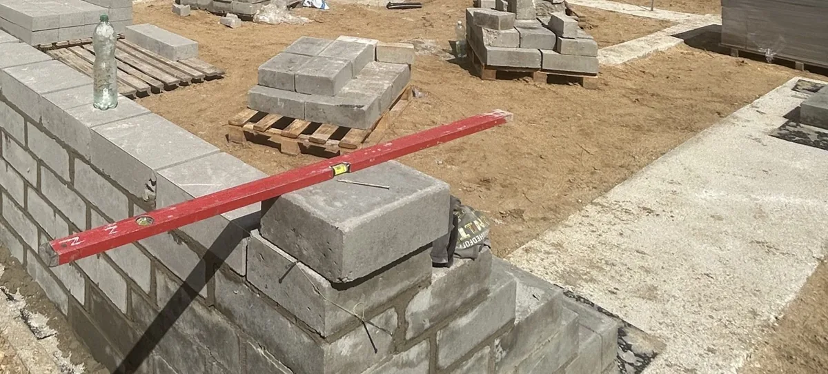 Świeżo wymurowana ściana z bloczków betonowych z poziomicą ułożoną na wierzchu